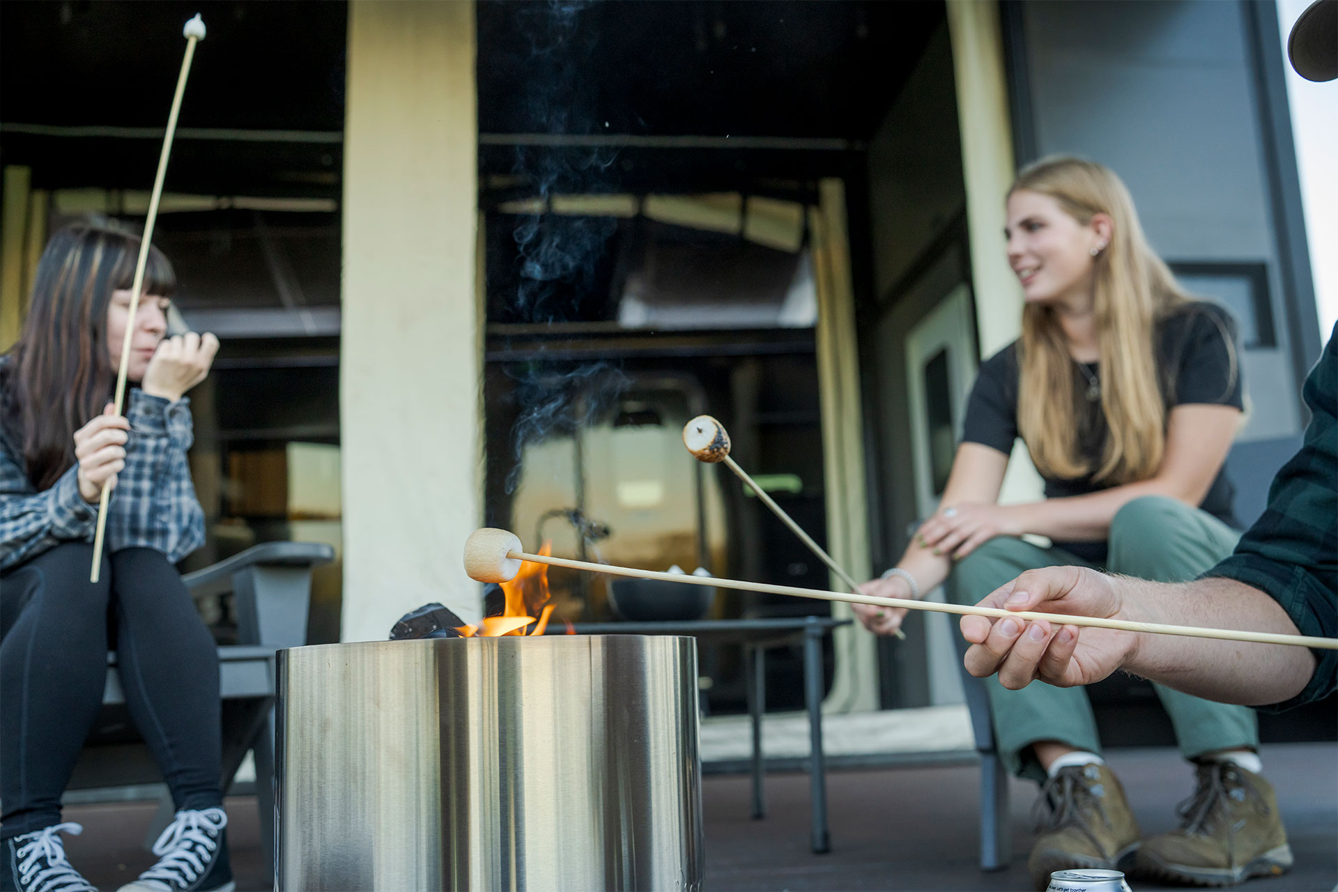 Guests gathered around a campfire beside an EO Canopy